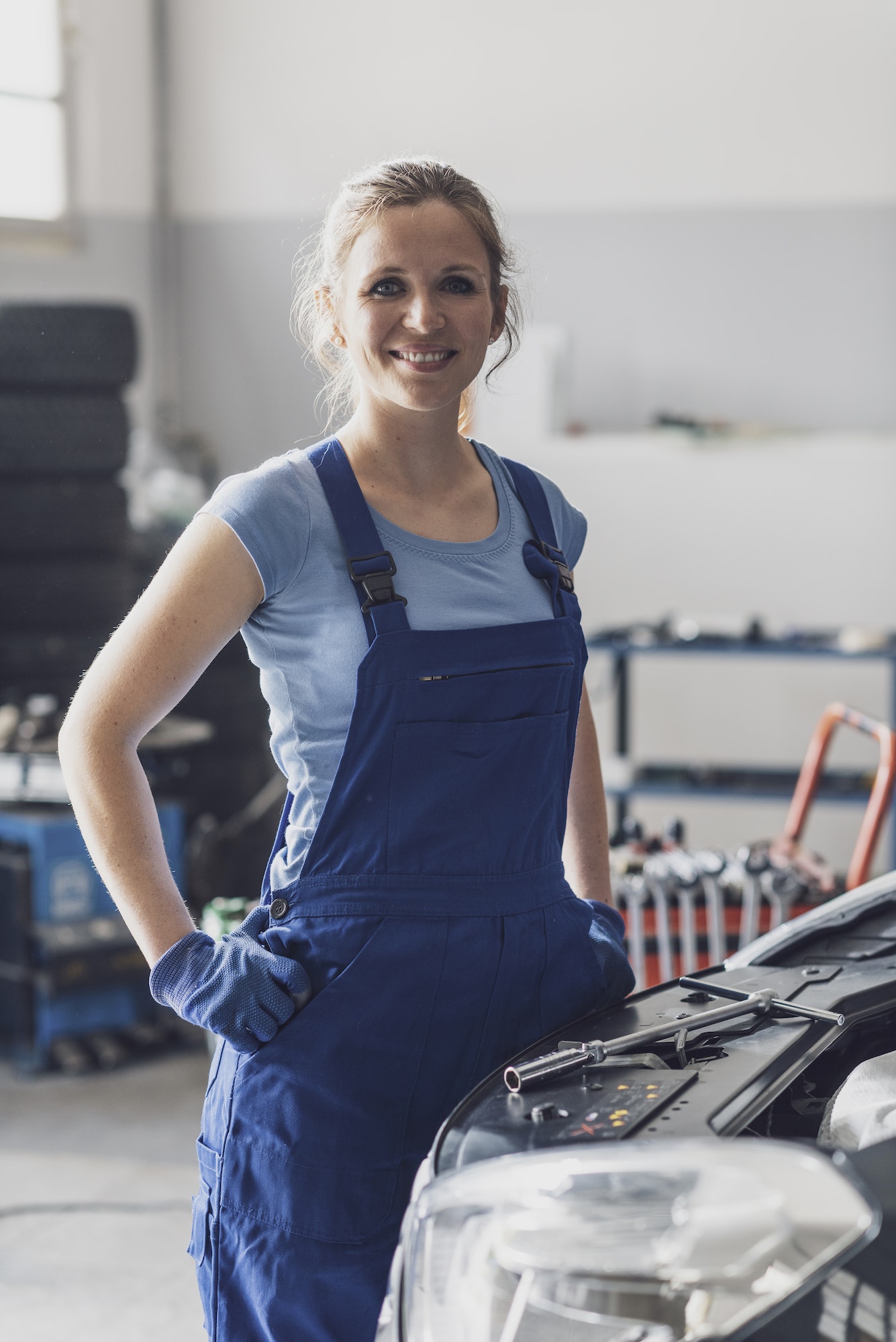 Confident female mechanic posing in the auto repair shop